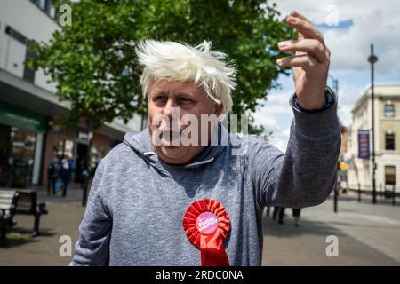 Londra, Regno Unito. 20 luglio 2023. Il laburista Alan Mitchell, Feltham Central, indossa una parrucca e impersona Boris Johnson durante le campagne con gli attivisti del partito laburista a Uxbridge, nel nord-ovest di Londra. I residenti locali nel collegio di Uxbridge e South Ruislip stanno votando in un'elezione suppletiva per scegliere il loro nuovo membro del Parlamento dopo le dimissioni del loro ex deputato, Boris Johnson. Altre due circoscrizioni, Selby e Ainsty, e Somerton e Frome, vinte dai conservatori alle ultime elezioni generali del 2019, oggi si tengono elezioni suppletive. Crediti: Stephen Chung / Alamy Live News Foto Stock