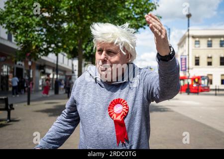 Londra, Regno Unito. 20 luglio 2023. Il laburista Alan Mitchell, Feltham Central, indossa una parrucca e impersona Boris Johnson durante le campagne con gli attivisti del partito laburista a Uxbridge, nel nord-ovest di Londra. I residenti locali nel collegio di Uxbridge e South Ruislip stanno votando in un'elezione suppletiva per scegliere il loro nuovo membro del Parlamento dopo le dimissioni del loro ex deputato, Boris Johnson. Altre due circoscrizioni, Selby e Ainsty, e Somerton e Frome, vinte dai conservatori alle ultime elezioni generali del 2019, oggi si tengono elezioni suppletive. Crediti: Stephen Chung / Alamy Live News Foto Stock