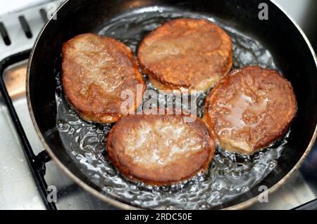 Vista ravvicinata di hamburger di manzo fritto piccante cucinato in una padella antiaderente con olio bollente poco profondo, fast food, cibo spazzatura, fast food fatti in casa, Foto Stock