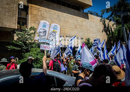 Tel Aviv, Israele. 18 luglio 2023. I manifestanti sventolano la bandiera israeliana davanti alla corte rabbinica di Tel Aviv durante una manifestazione a Tel Aviv. Decine di migliaia di manifestanti martedì hanno bloccato autostrade e stazioni ferroviarie e hanno marciato nel centro di Tel Aviv durante una giornata di manifestazioni a livello nazionale contro il controverso piano di revisione giudiziaria del primo ministro Benjamin Netanyahu. Credito: SOPA Images Limited/Alamy Live News Foto Stock