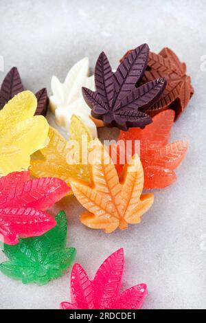 Dolci a base di cannabis. Una selezione di cioccolato, caramelle dure e toffee infusi con olio CBD a forma di foglia di cannabis Foto Stock