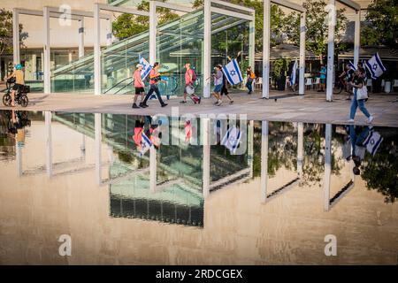 Tel Aviv, Israele. 18 luglio 2023. I manifestanti hanno la bandiera israeliana mentre si riuniscono per una manifestazione a Tel Aviv. Decine di migliaia di manifestanti martedì hanno bloccato autostrade e stazioni ferroviarie e hanno marciato nel centro di Tel Aviv durante una giornata di manifestazioni a livello nazionale contro il controverso piano di revisione giudiziaria del primo ministro Benjamin Netanyahu. (Foto di Eyal Warshavsky/SOPA Images/Sipa USA) credito: SIPA USA/Alamy Live News Foto Stock