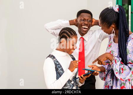 Foto di diversi gruppi di professionisti aziendali che discutono di soluzioni tecnologiche in un ambiente africano Foto Stock