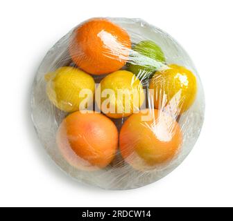 Involucro di plastica con diversi agrumi su sfondo bianco Foto Stock