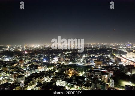 tiro aereo con treppiede con drone che mostra il paesaggio urbano di jaipur delhi con fuochi d'artificio, razzi, pirotecnici e lanterne del cielo di notte per celebrare il makar Foto Stock