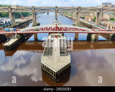 Newcastle, Regno Unito - 20 luglio 2023: Il ponte altalenante rosso sul fiume Tyne. Ponte stradale e ferroviario di alto livello sullo sfondo. Foto Stock