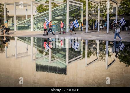 Tel Aviv, Israele. 18 luglio 2023. I manifestanti hanno la bandiera israeliana mentre si riuniscono per una manifestazione a Tel Aviv. Decine di migliaia di manifestanti martedì hanno bloccato autostrade e stazioni ferroviarie e hanno marciato nel centro di Tel Aviv durante una giornata di manifestazioni a livello nazionale contro il controverso piano di revisione giudiziaria del primo ministro Benjamin Netanyahu. (Immagine di credito: © Eyal Warshavsky/SOPA Images via ZUMA Press Wire) SOLO PER USO EDITORIALE! Non per USO commerciale! Foto Stock