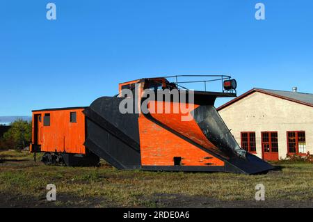 Un vagone ferroviario d'epoca si trova accanto ai binari ferroviari abbandonati nella Upper Penninsula, Michigan. Il vagone ferroviario è dotato di un aratro montato sulla parte anteriore per lo sgombero della neve su tra Foto Stock