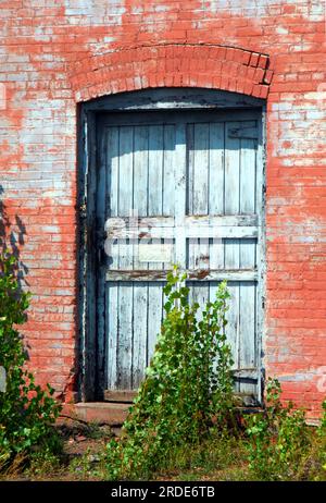 La porta bianca è circondata da pietra arenaria rossa locale. L'edificio fa parte della vecchia Quincy Copper Smelter. Foto Stock