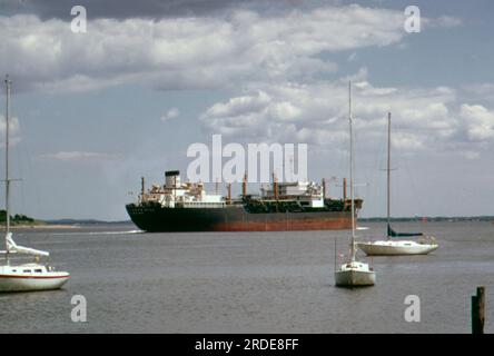 Le barche a vela fanno un giro all'ancora al Raritan Yacht Club di Perth Amboy, dove il fiume Raritan si unisce all'Arthur Kill. Una nave cisterna esso lascia la Arthur Kill per la baia, luglio 1973 Foto Stock