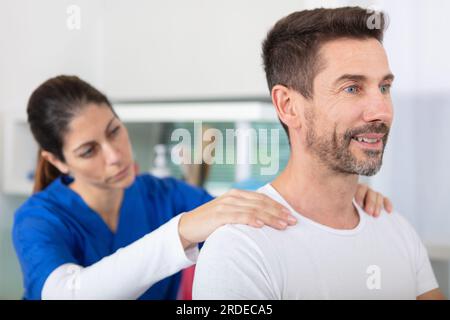 fisioterapista che fa un massaggio alla schiena al cliente Foto Stock