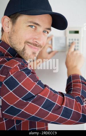 men regola la temperatura sul pannello di controllo Foto Stock