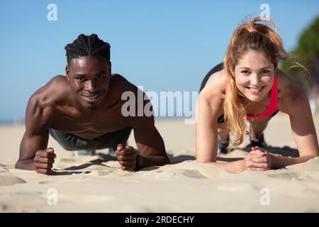 giovani coppie che si allenano in spiaggia Foto Stock