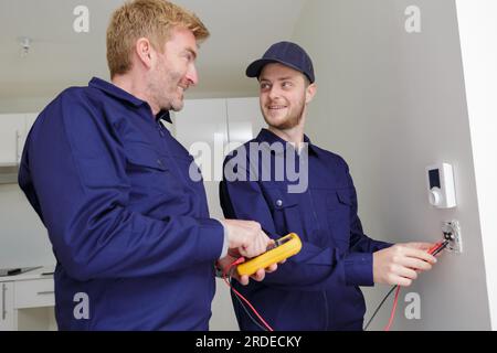 Elettricista con apprendista lavorare nella nuova casa Foto Stock