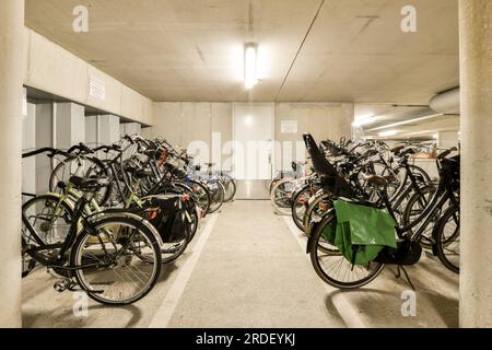 diverse biciclette sono parcheggiate in un parcheggio senza nessuno a terra, e c'è un'area all'aperto per loro Foto Stock