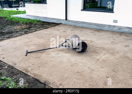 Sabbia gialla ondulata con un rullo d'acciaio per una piscina da giardino. Foto Stock