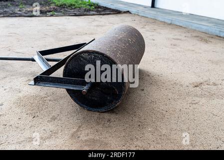 Sabbia gialla ondulata con un rullo d'acciaio per una piscina da giardino. Foto Stock