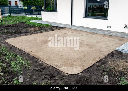 Sabbia gialla ondulata con un rullo d'acciaio per una piscina da giardino, quadrato vuoto visibile. Foto Stock