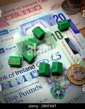 Spese di alloggio (acquisto o affitto) in Irlanda del Nord, banconote, monete, case monopolio Foto Stock