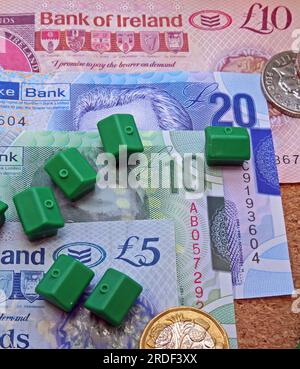 Spese di alloggio (acquisto o affitto) in Irlanda del Nord, banconote, monete, case monopolio Foto Stock