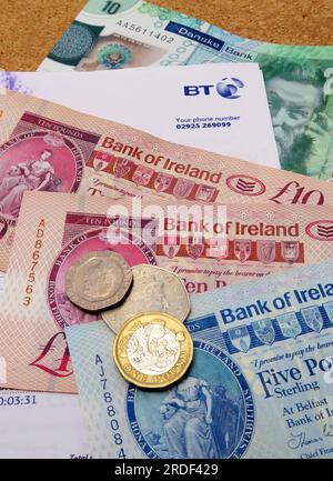 Costi della bolletta delle famiglie telefono, Internet, BT in Irlanda del Nord, banconote in sterline, monete, aumento della povertà causato dall'inflazione Foto Stock