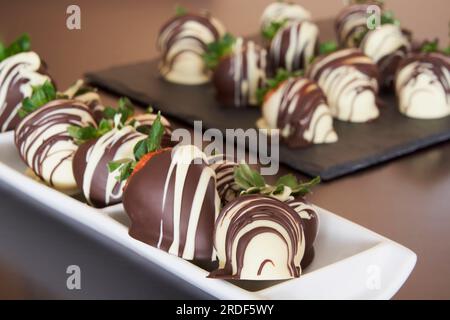 Primo piano delle fragole ricoperte di cioccolato bianco e fondente Foto Stock