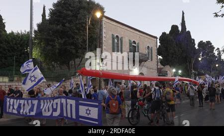 I manifestanti anti anti-governativi trasportano un massiccio pallone che raggiunge i 100 metri di lunghezza per segnare la linea rossa attraversata dal primo ministro Benjamin mentre marciano durante la "notte della resistenza" per protestare contro Netanyahu e il piano del sistema giudiziario del governo israeliano di estrema destra che mira a indebolire la Corte Suprema del paese a luglio 20, 2023 a Gerusalemme, Foto Stock