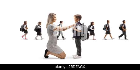 Madre che aiuta il figlio a prepararsi per la scuola e altri bambini che camminano nella schiena isolati su sfondo bianco Foto Stock