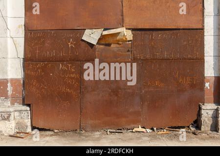 L'Avana, Cuba - 27 maggio 2023: Una grande porta metallica arrugginita di un garage. Una parte rotta della porta è coperta di cartone. Foto Stock