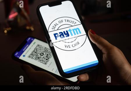 In questa foto, il logo Paytm e il codice QR PhonePe sono visualizzati sullo schermo dei telefoni cellulari a Guwanati, India, il 19 luglio 2023. Foto Stock