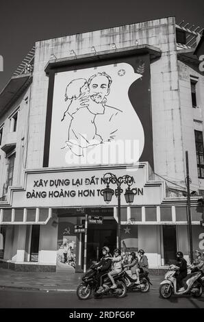 Il gigantesco ritratto del leader rivoluzionario del Vietnam ho chi Minh che tiene un bambino nel vecchio edificio dell'ufficio postale di Trang Tien ad Hanoi, in Vietnam. Il co Foto Stock