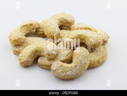 Biscotti a forma di mezzaluna cosparsi di zucchero in polvere. Primi piani dei gustosi biscotti su sfondo bianco. Biscotti fatti in casa con Shortbread Foto Stock