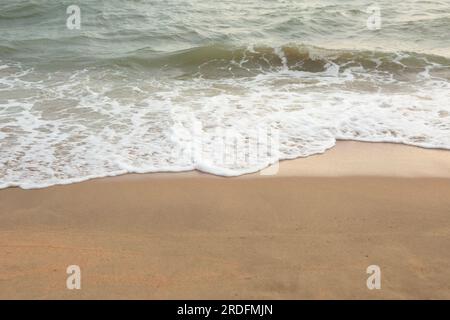 Sea Foam Wave si schianta sulla spiaggia di sabbia. Summer Copyspace Foto Stock