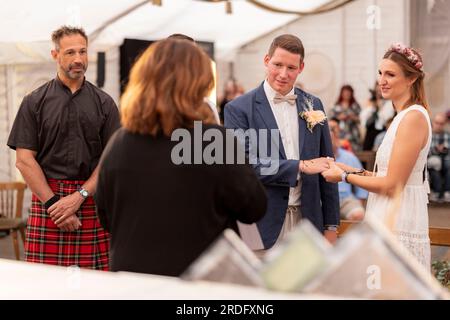 Weeze, Germania. 21 luglio 2023. Alina e Ivo da Heinsberg al loro matrimonio civile al festival di Weeze, il registrar Birgit Tönnesen sposa la coppia, come testimone con il musicista statunitense ed ex bassista della rock band Bloodhound Gang 'Evil' Jared Hasselhoff (l). Parookaville Electronic Music Festival 2023. Parookaville è uno dei più grandi festival di musica elettronica in Europa. Il concetto alla base del festival è una città costruita solo per festeggiare. Credito: Christoph Reichwein/dpa/Alamy Live News Foto Stock