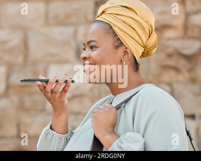 Telefono, riconoscimento vocale e donna in città che cammina in una strada urbana fino al suo ufficio. Tecnologia, designer donna allegra e africana che registra un Foto Stock