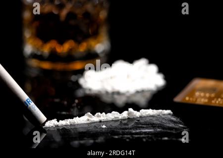 linea di cocaina bianca, carta di credito dorata e vetro con rum Foto Stock