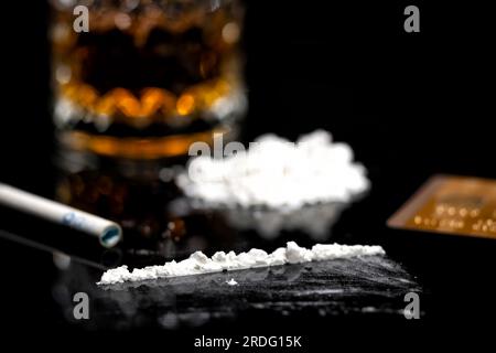 linea di cocaina bianca, carta di credito dorata e vetro con rum Foto Stock