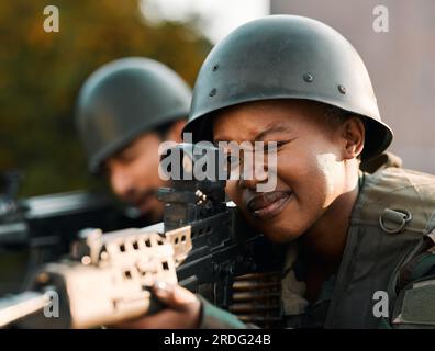 Esercito, persone e armi da fuoco per l'addestramento, la difesa o l'alimentazione sul tetto per la mira, il tiro o la pratica. Militare, arma e donna nera con un uomo soldato e.. Foto Stock