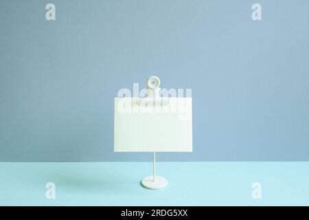 Cialda per appunti vuota e supporto sulla scrivania blu. sfondo a parete blu Foto Stock