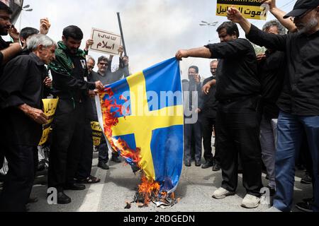 Teheran, Teheran, Iran. 21 luglio 2023. I manifestanti iraniani bruciano una bandiera svedese, durante una protesta per l'incendio di un Corano in Svezia, a Teheran, in Iran. Giovedì, un uomo che si è identificato nei media svedesi come rifugiato dall'Iraq ha bruciato un Corano per la seconda volta nel centro di Stoccolma. (Immagine di credito: © Sobhan Farajvan/Pacific Press via ZUMA Press Wire) SOLO USO EDITORIALE! Non per USO commerciale! Foto Stock