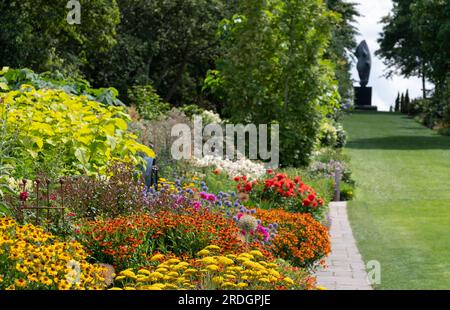 Splendidi e colorati bordi di fiori misti al RHS Wisley Garden, Surrey, Regno Unito. Le ampie aiuole hanno principalmente piante perenni che crescono in esse. Foto Stock