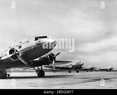 New York, New York: 1937 DC-3B TWA presso l'Aeroporto di North Beach, ora la Guardia, a New York, con vari altri DC-3 di altre compagnie aeree sullo sfondo Foto Stock