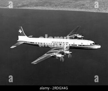 California: Gennaio 1957 Uno Swiss Air Douglas DC-7C che vola lungo la costa della California meridionale. Foto Stock