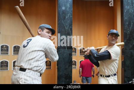 Cooperstown, Stati Uniti. 21 luglio 2023. I visitatori della National Baseball Hall of Fame esaminano le targhe nella Grand Hall mentre le statue di scultura di Basswood di Babe Ruth e Ted Williams si trovano vicino a Cooperstown, New York, venerdì 21 luglio 2023. Foto di Bill Greenblatt/UPI credito: UPI/Alamy Live News Foto Stock