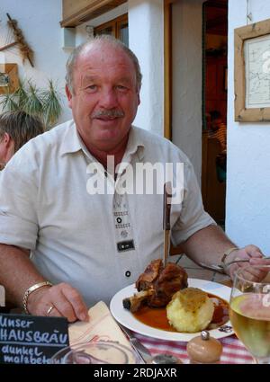 Uomo con nocciolo di maiale e gnocchi, nel pub della birreria Allgäu Foto Stock