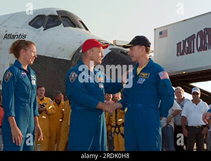 Il pilota dello Space Shuttle Atlantis Doug Hurley (al centro) stringe la mano al comandante Chris Ferguson (a destra) mentre lo specialista di missione Sandy Magnus guarda dopo il loro ritorno dalla missione STS-135 giovedì 21 luglio 2011 al Kennedy Space Center della NASA a Cape Canaveral, Brevard County, Florida, USA. STS-135 è stata la missione finale sia per l'Atlantis Orbiter che per il programma di 30 anni di Space Shuttle. (Foto Apex MediaWire di Kim Shiflett/NASA) Foto Stock