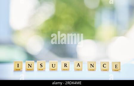 Blocchi di legno, assicurazione e parole sul tavolo, scritte o lettere con mockup. Sicurezza, garanzia e cubi con testo per l'assistenza sanitaria, la sicurezza e la medicina Foto Stock
