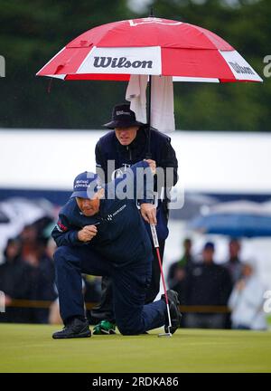 Padraig Harrington della Repubblica d'Irlanda allinea un putt sul secondo verde sotto un ombrello durante il terzo giorno dell'Open al Royal Liverpool, Wirral. Data foto: Sabato 22 luglio 2023. Foto Stock