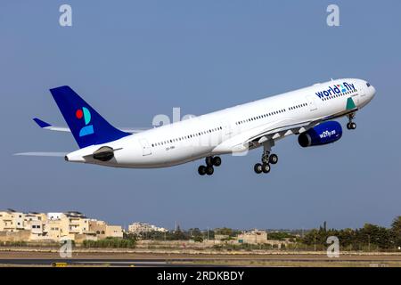 World 2 Fly Airbus A330-343 (Reg.: CS-TRH) in partenza da Malta dopo essere stato dipinto con lo schema di colori di questa compagnia aerea, è arrivato in vernice gialla il 23 giugno. Foto Stock