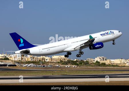 World 2 Fly Airbus A330-343 (Reg.: CS-TRH) in partenza da Malta dopo essere stato dipinto con lo schema di colori di questa compagnia aerea, è arrivato in vernice gialla il 23 giugno. Foto Stock